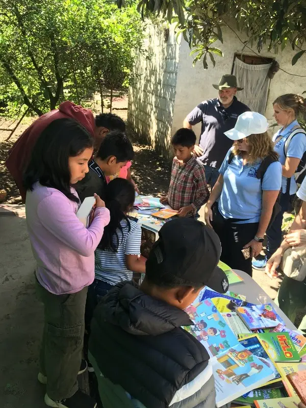 Grupo de niños estudiando bajo un árbol