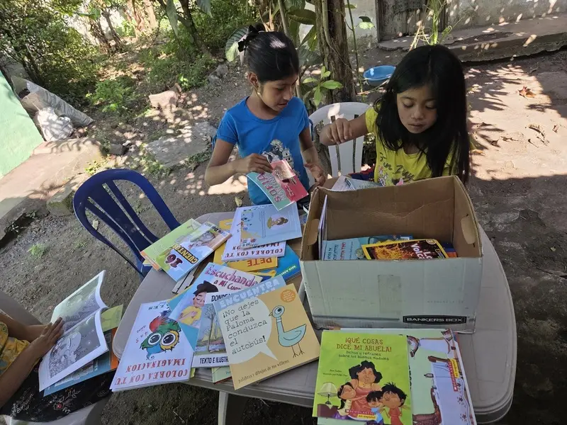 Niñas eligiendo libros de una caja