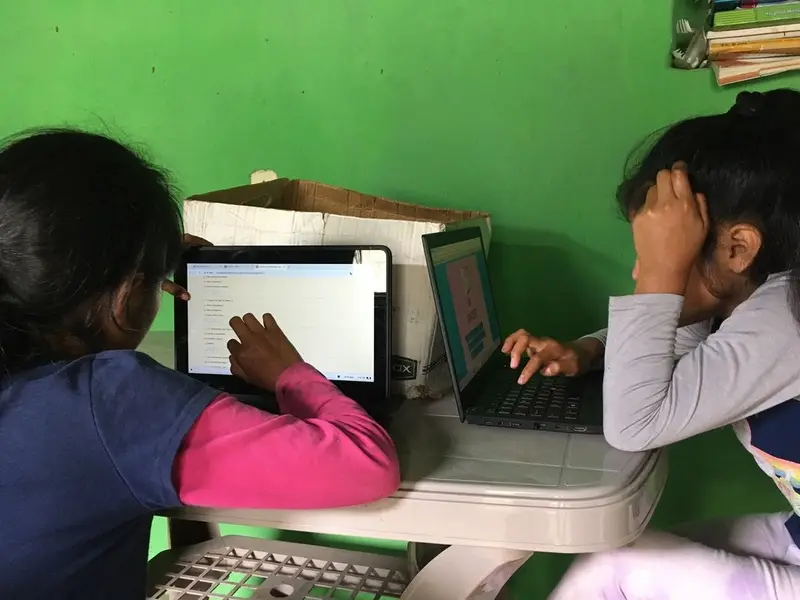 Dos niñas practicando en laptops
