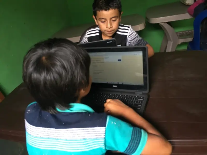 Dos niños practicando en una laptop