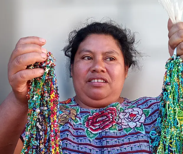Mujer artesana mostrando collares hechos a mano